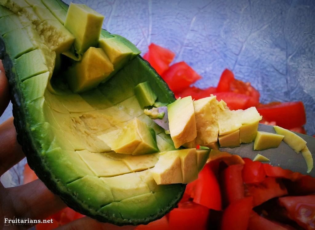 Cutting the avocado inside of its shell.